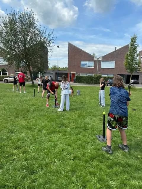 Spelers met knuppels op een grasveld bij de club